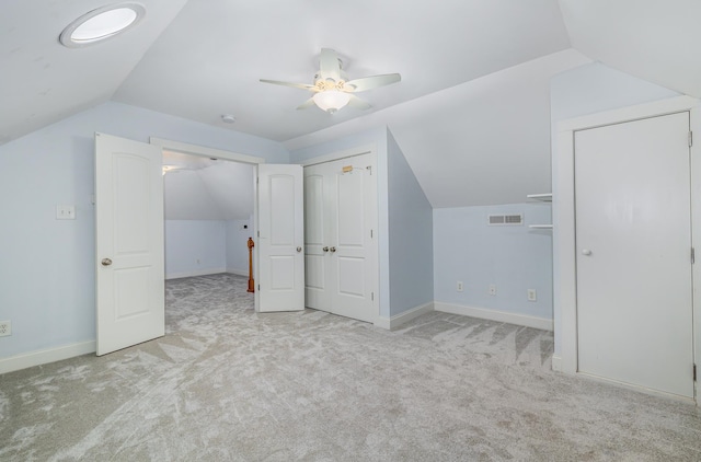 additional living space featuring light carpet, lofted ceiling, and ceiling fan