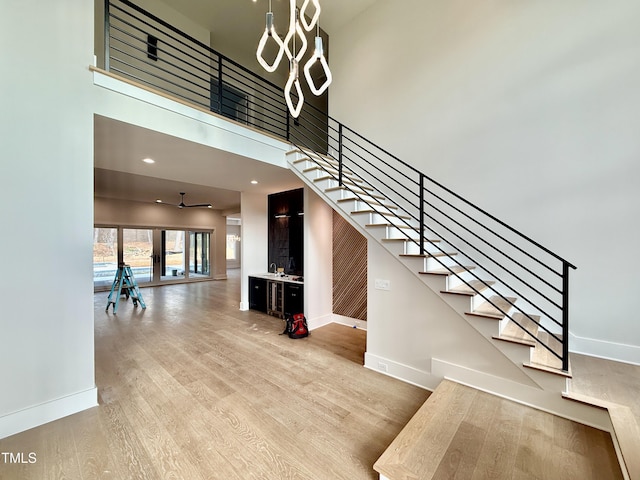 staircase featuring a high ceiling and hardwood / wood-style floors