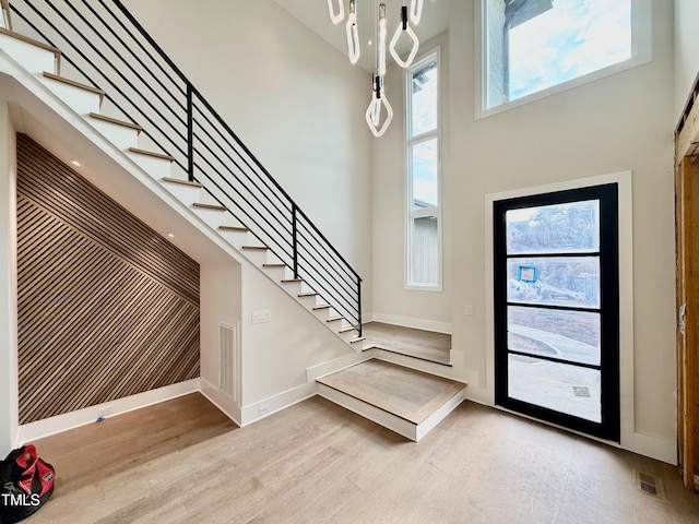 entrance foyer featuring light hardwood / wood-style flooring and a high ceiling