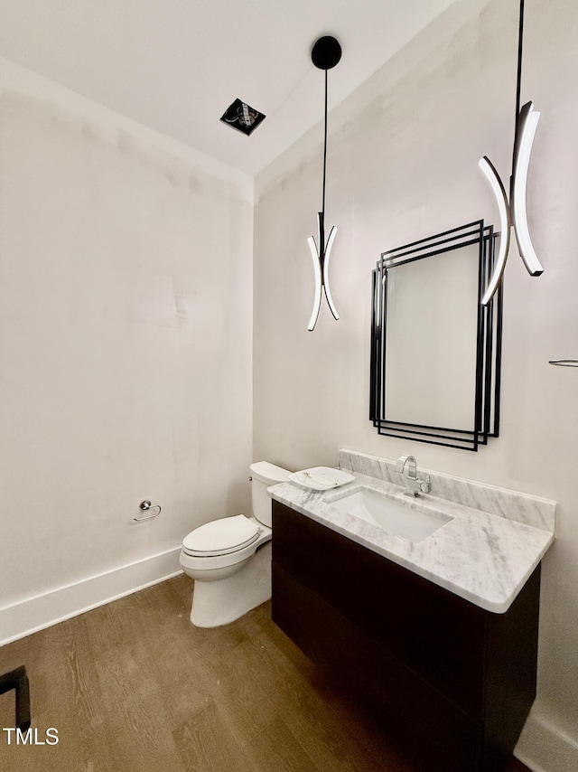 bathroom featuring vanity, toilet, and wood-type flooring