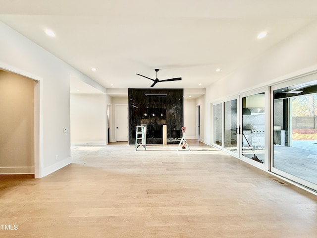 unfurnished living room with ceiling fan and light hardwood / wood-style floors