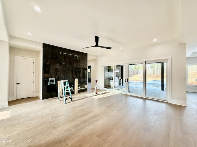 unfurnished living room featuring ceiling fan and light wood-type flooring