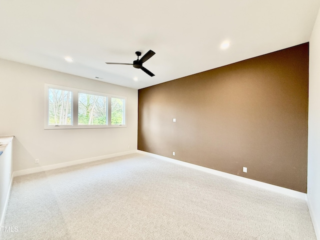 carpeted spare room featuring ceiling fan