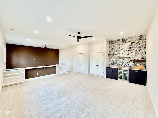 unfurnished living room with ceiling fan and carpet