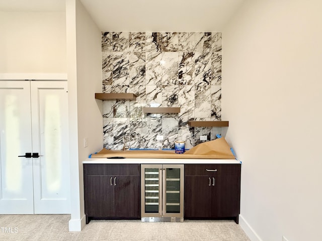 bar with wine cooler and dark brown cabinetry