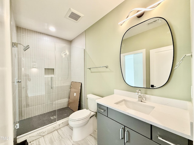 bathroom featuring vanity, toilet, and walk in shower