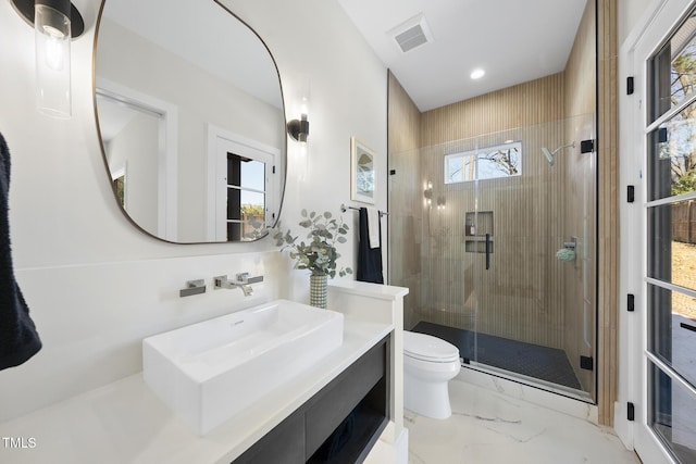 bathroom featuring marble finish floor, visible vents, toilet, a shower stall, and vanity