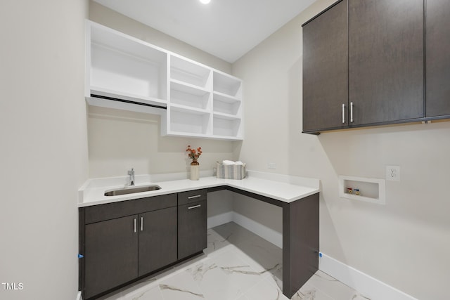 laundry area featuring washer hookup, marble finish floor, cabinet space, a sink, and baseboards