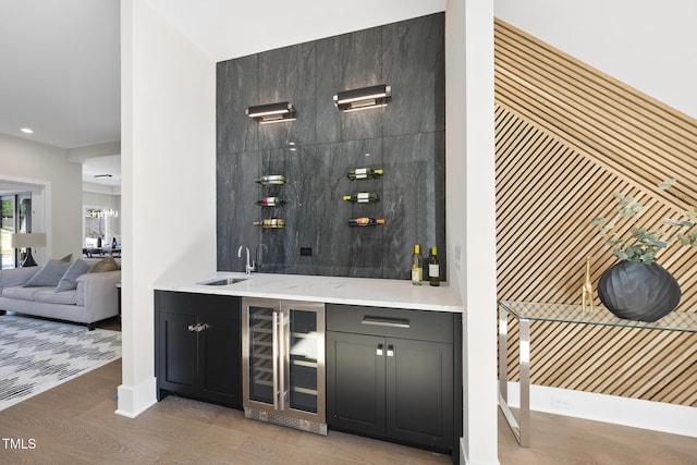 wine area with wine cooler, indoor wet bar, and a sink