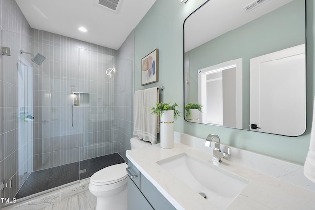 bathroom featuring toilet, a stall shower, vanity, and visible vents