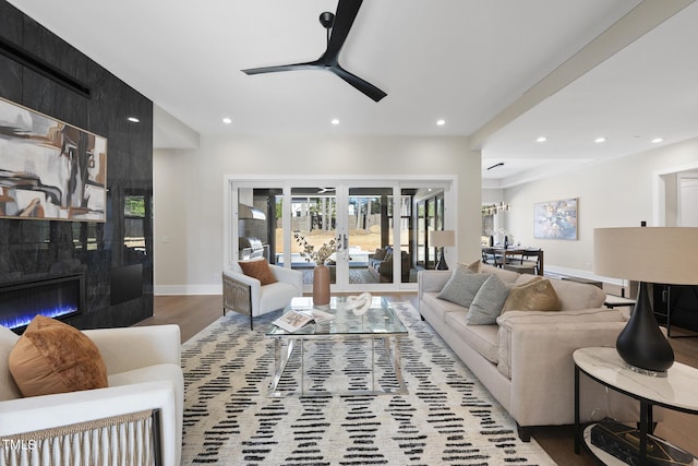 living room featuring recessed lighting, baseboards, a tiled fireplace, and wood finished floors