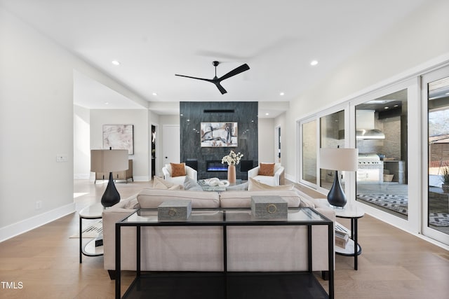 living area with a fireplace, wood finished floors, a ceiling fan, and recessed lighting