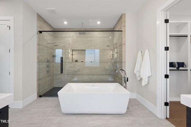 full bathroom featuring visible vents, a freestanding bath, a stall shower, vanity, and baseboards