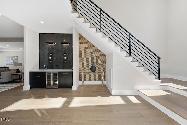 bar with wine cooler, wood finished floors, and a dry bar