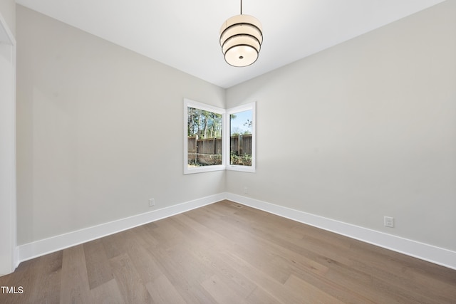 unfurnished room with baseboards and wood finished floors