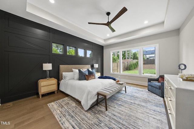 662 Manchester Dr, Raleigh, NC 27609 - bedroom with a raised ceiling, light wood finished floors, recessed lighting, and ceiling fan