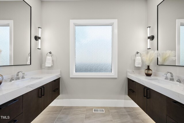662 Manchester Dr, Raleigh, NC 27609 - full bath featuring plenty of natural light, baseboards, and two vanities