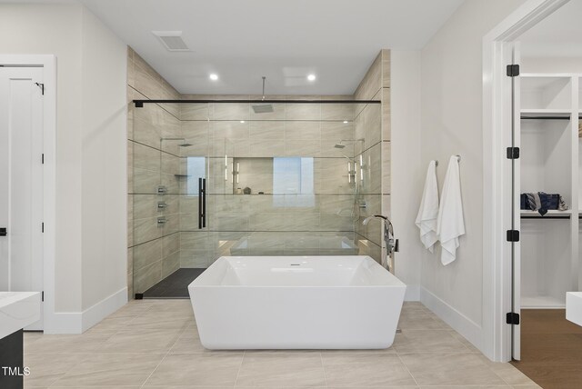 662 Manchester Dr, Raleigh, NC 27609 - full bathroom featuring a stall shower, baseboards, tile patterned floors, recessed lighting, and a walk in closet