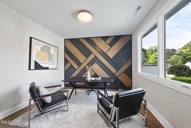 662 Manchester Dr, Raleigh, NC 27609 - sitting room with baseboards, an accent wall, and wood finished floors