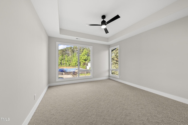 662 Manchester Dr, Raleigh, NC 27609 - empty room featuring baseboards, a ceiling fan, a tray ceiling, and carpet flooring