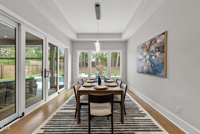 662 Manchester Dr, Raleigh, NC 27609 - dining space with a raised ceiling, dark wood-type flooring, and baseboards