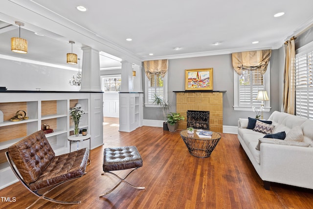 living room with a fireplace, wood finished floors, and crown molding