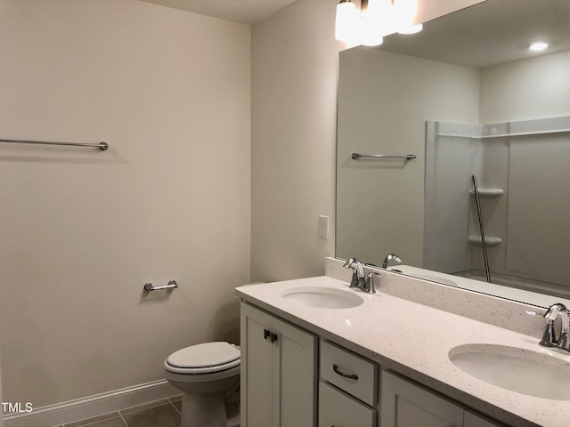 full bath featuring double vanity, toilet, a sink, and tile patterned floors