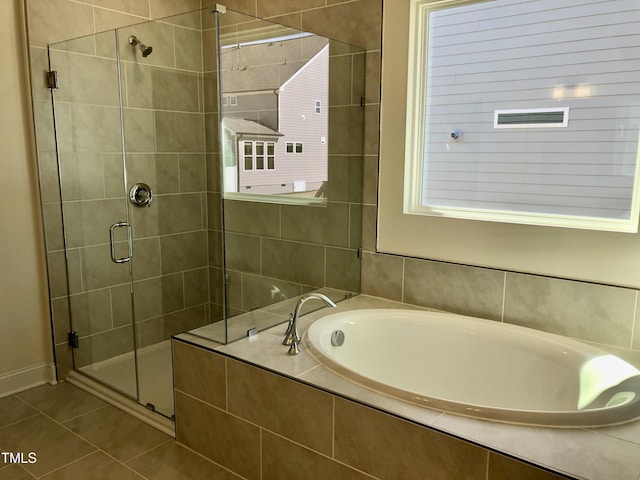 bathroom with a stall shower, tile patterned flooring, and a garden tub