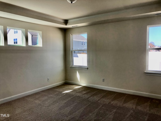 unfurnished room featuring plenty of natural light, baseboards, dark colored carpet, and crown molding