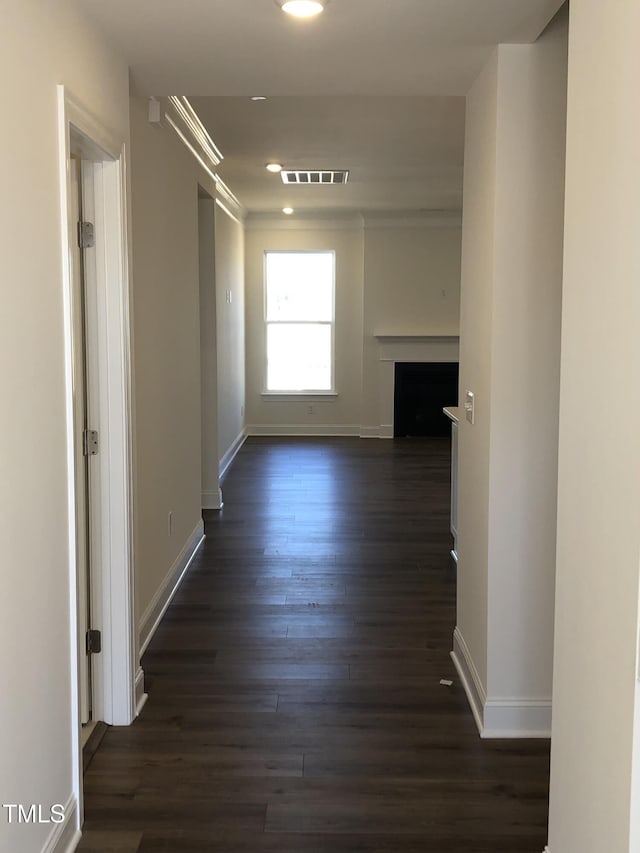 corridor featuring dark wood-style floors, recessed lighting, visible vents, and baseboards