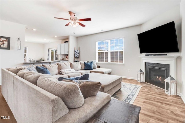 living room featuring light hardwood / wood-style floors and ceiling fan