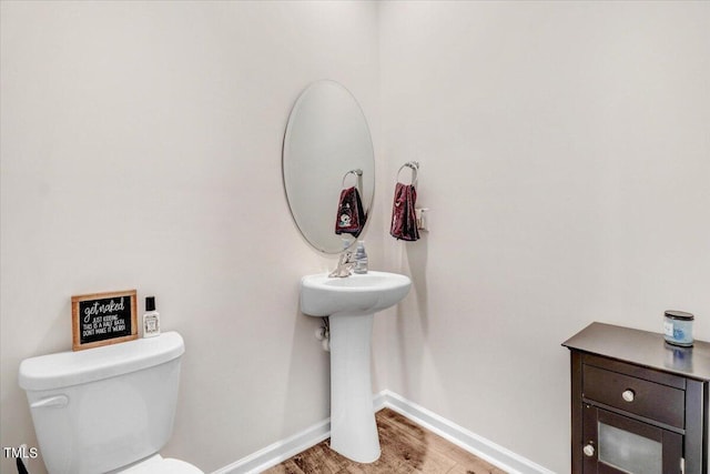 bathroom featuring hardwood / wood-style flooring and toilet