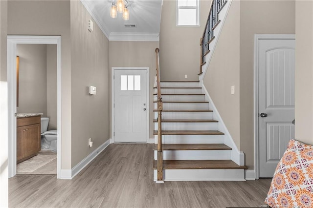 entrance foyer with crown molding and light wood-type flooring