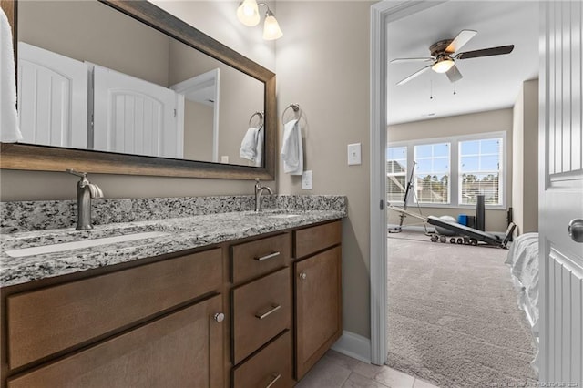 full bathroom with double vanity, a ceiling fan, baseboards, and a sink