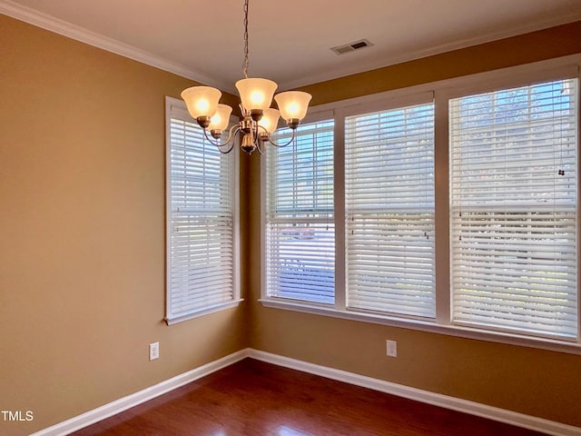 unfurnished dining area with a healthy amount of sunlight, ornamental molding, dark hardwood / wood-style flooring, and a chandelier