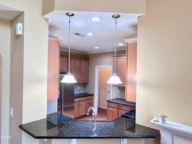 kitchen featuring stainless steel fridge, kitchen peninsula, dark stone countertops, and pendant lighting