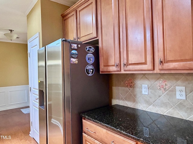 kitchen with stainless steel refrigerator with ice dispenser, tasteful backsplash, and dark stone counters