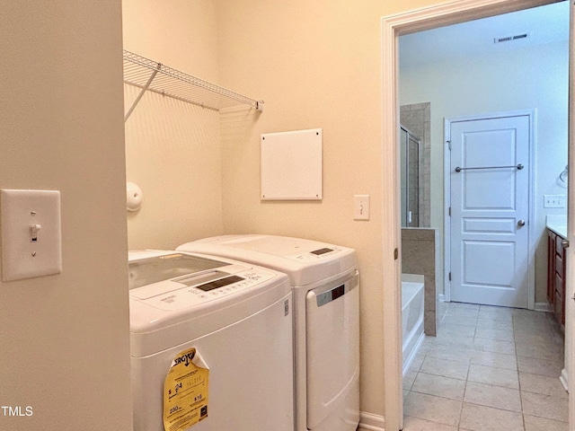 laundry area featuring independent washer and dryer and light tile patterned floors