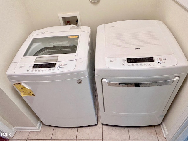 washroom with light tile patterned floors and separate washer and dryer