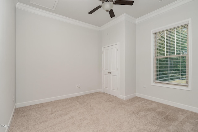 carpeted spare room with ceiling fan and ornamental molding