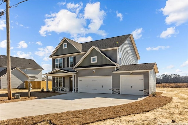 craftsman house with concrete driveway, stone siding, an attached garage, fence, and board and batten siding