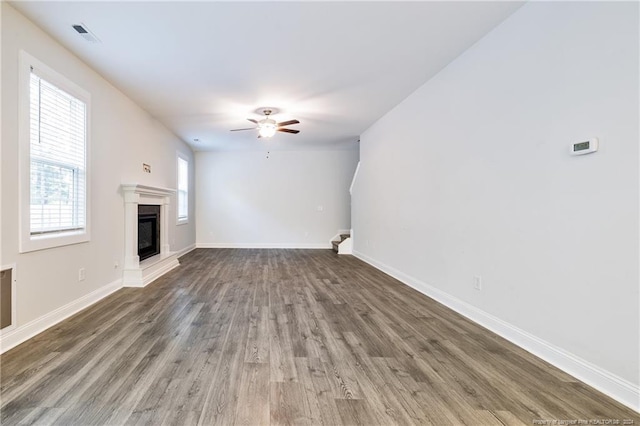 unfurnished living room with ceiling fan and dark hardwood / wood-style flooring