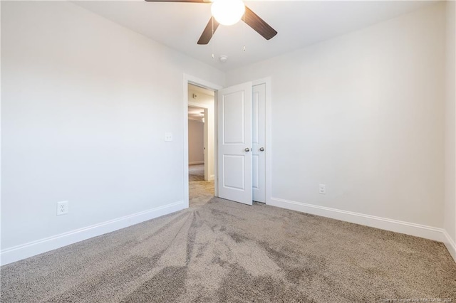 unfurnished room with ceiling fan and carpet