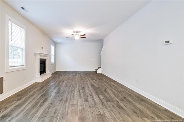 400 Jax Ct, Fayetteville, NC 28312 - unfurnished living room with ceiling fan, wood finished floors, a glass covered fireplace, and baseboards