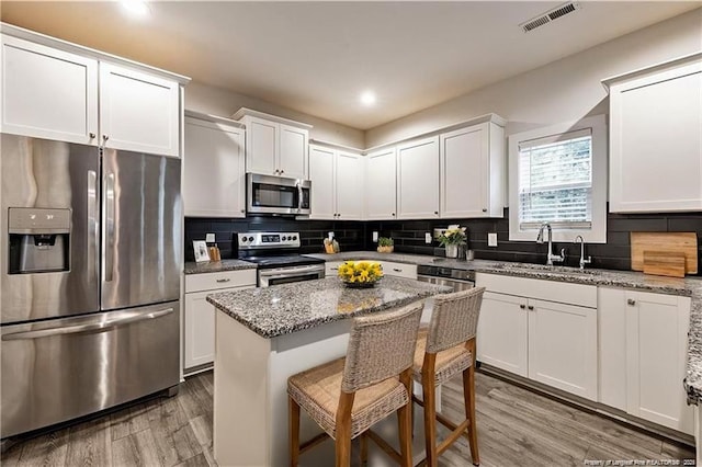 400 Jax Ct, Fayetteville, NC 28312 - kitchen with stainless steel appliances, a sink, light wood-type flooring, white cabinets, and recessed lighting