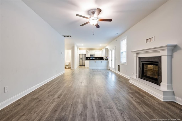 400 Jax Ct, Fayetteville, NC 28312 - unfurnished living room featuring a ceiling fan, dark wood-style flooring, a glass covered fireplace, and baseboards