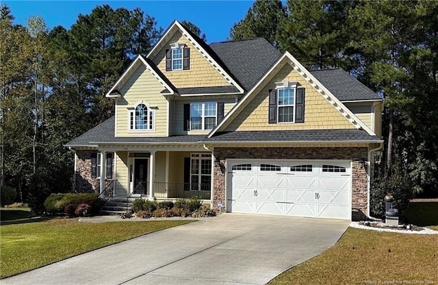 craftsman house featuring a front yard, a porch, and a garage