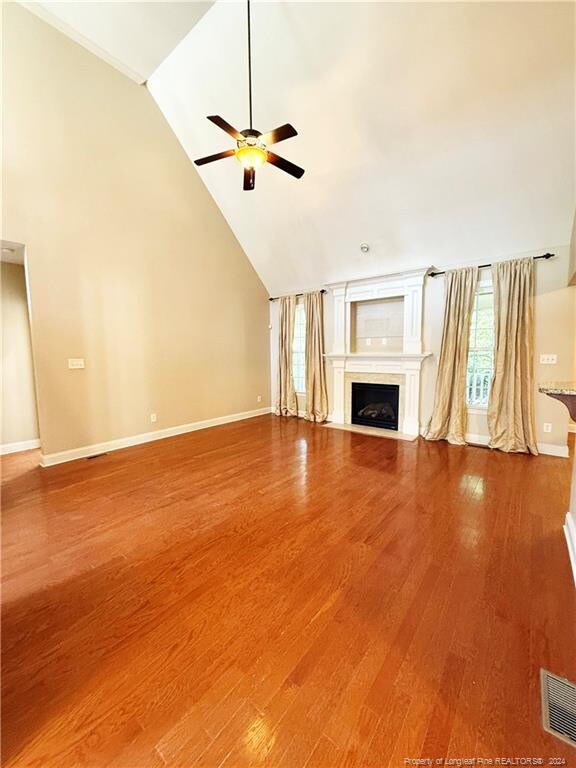 unfurnished living room featuring hardwood / wood-style floors, high vaulted ceiling, and a wealth of natural light