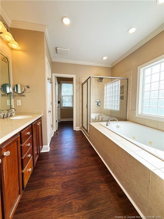 bathroom featuring hardwood / wood-style flooring, independent shower and bath, a wealth of natural light, and ornamental molding