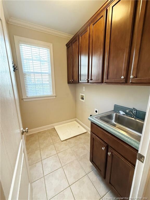 clothes washing area featuring hookup for an electric dryer, hookup for a washing machine, ornamental molding, and sink